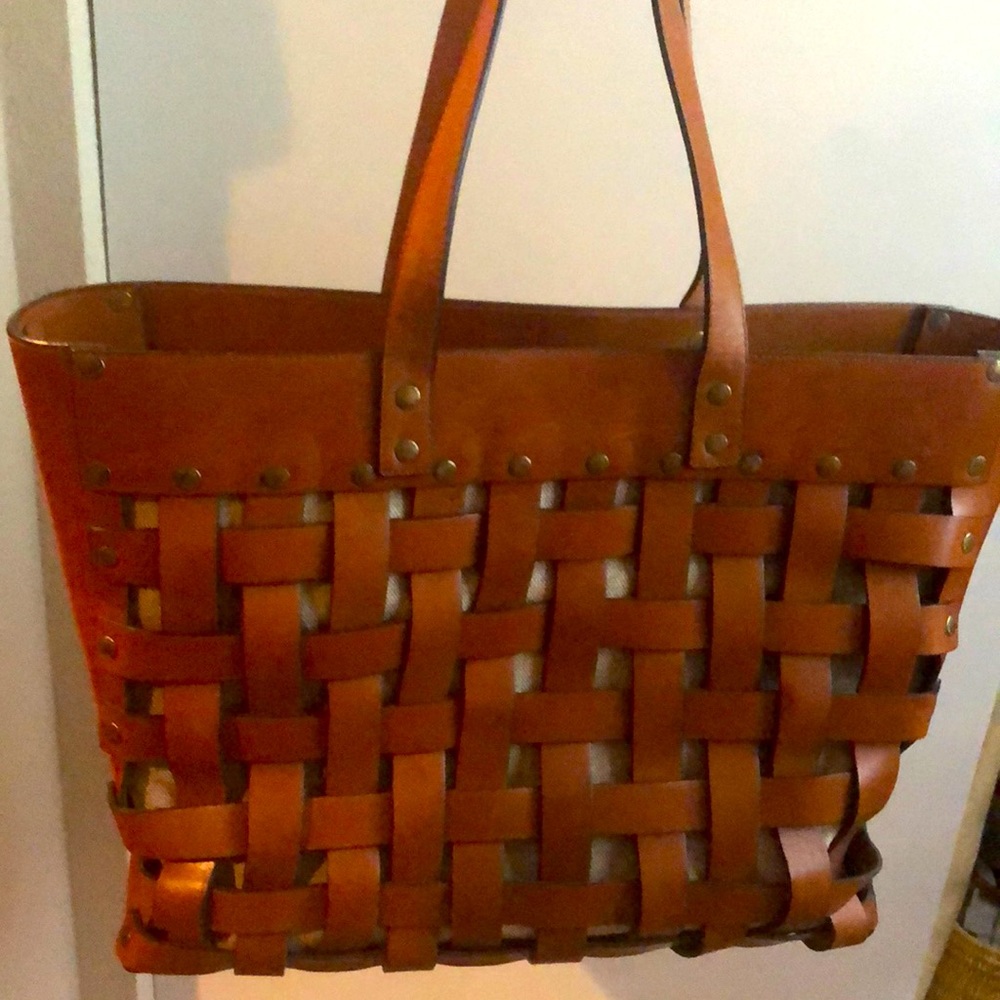 Leather bag with khaki lining. 14” H; 18” W; 6.5”D